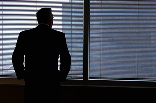 homme debout de dos fenêtre songeur lâcher prise