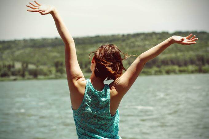 Femme heureuse devant un lac