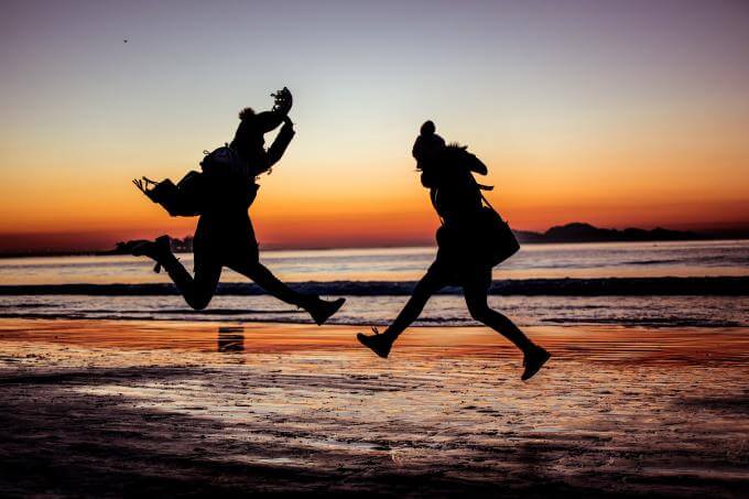 deux personnes qui sautent sur la plage 